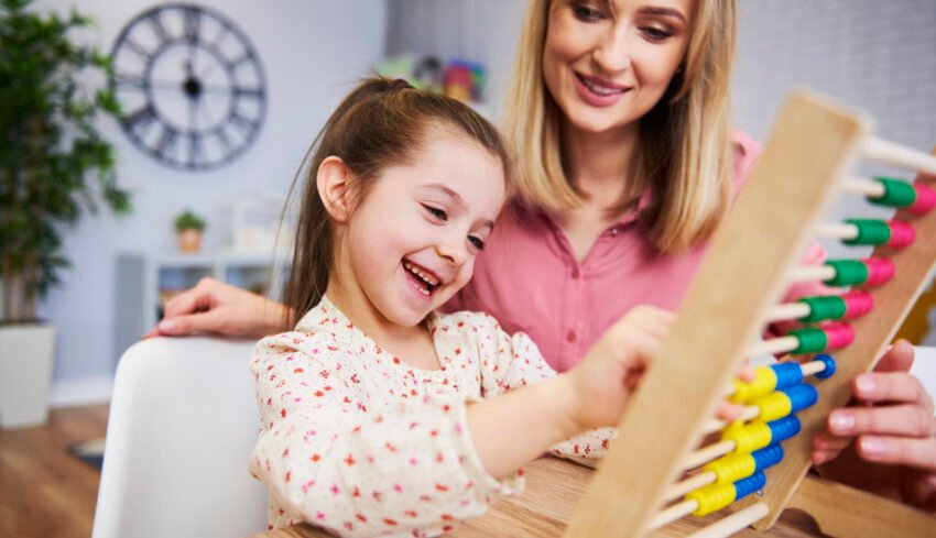 Girl and teacher using an abacus during homeschooling